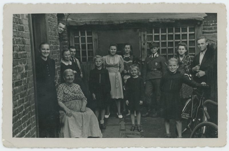 Grupa kobiet i mężczyzn przed domem