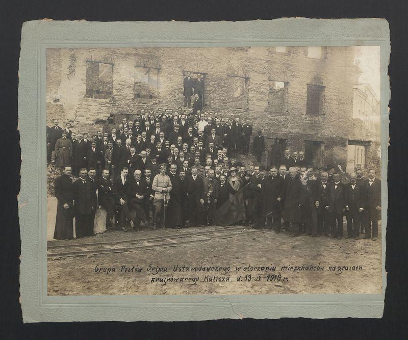 Grupa Posłów Sejmu Ustawodawczego w otoczeniu mieszkańców na gruzach zrujnowanego Kalisza d. 13-IV-1919r. 