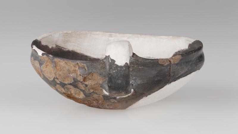 Czerpak o wklęsłym dnie, półkolistym brzuścu, brzegu zaokrąglonym do środka. Wnętrze zdobione odciskiem koła i skośnymi rowkami