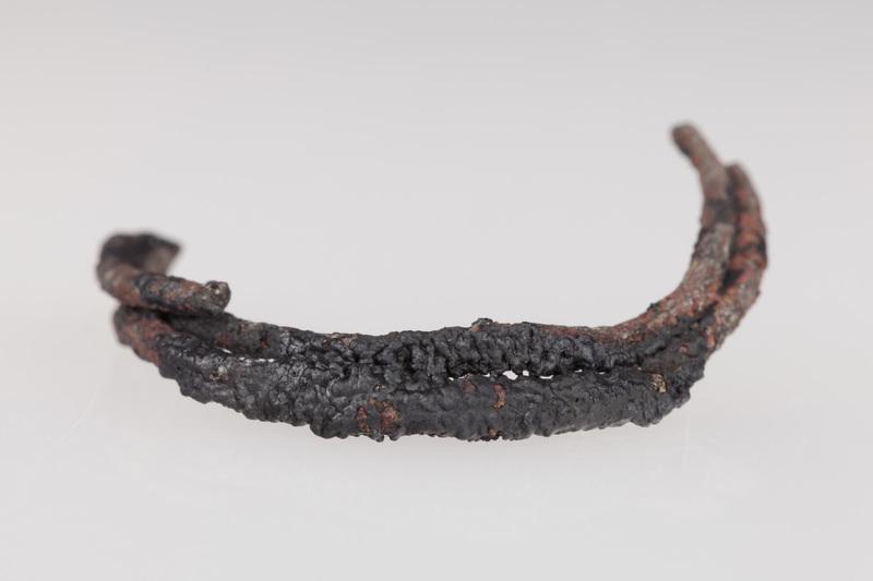 Fragmenty ozdób wykonanych z brązu, przepalonych na stosie, w tym skręt i szpila