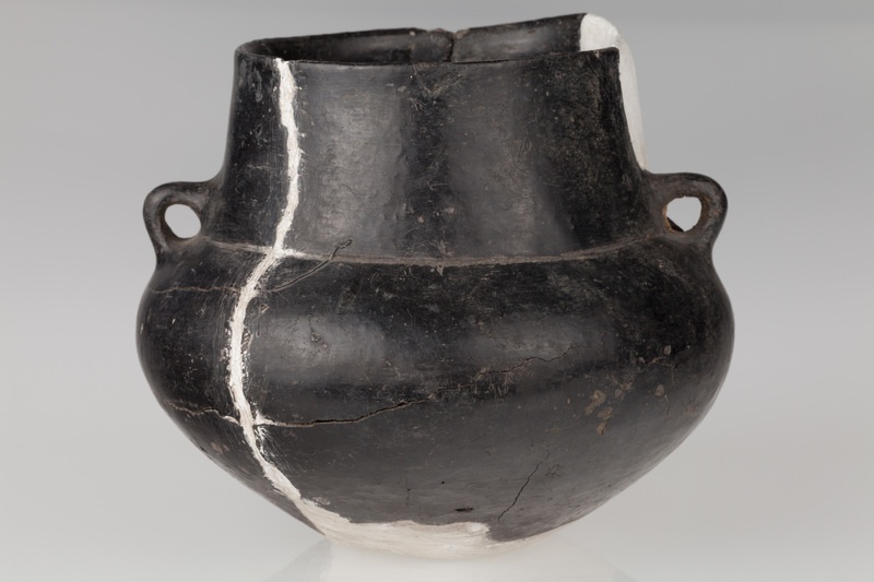 Amfora o baniastym brzuścu, stożkowatej szyjce, zaopatrzona w dwa ucha. Naczynie zdobione dookolnym rowkiem