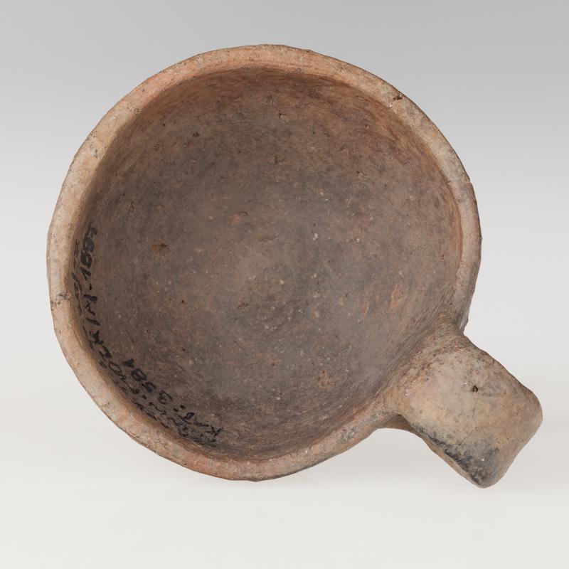 Czerpak półkulisty z wklęsłym dnem, zdobiony dookolnym rytym rowkiem i zwężającymi się trójkątami