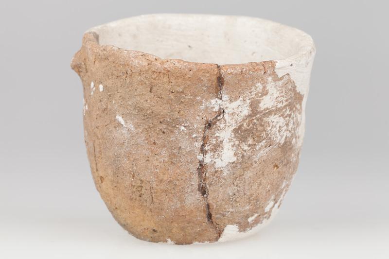 Miniaturowy garnek jajowaty, zaopatrzony w guzek poniżej krawędzi