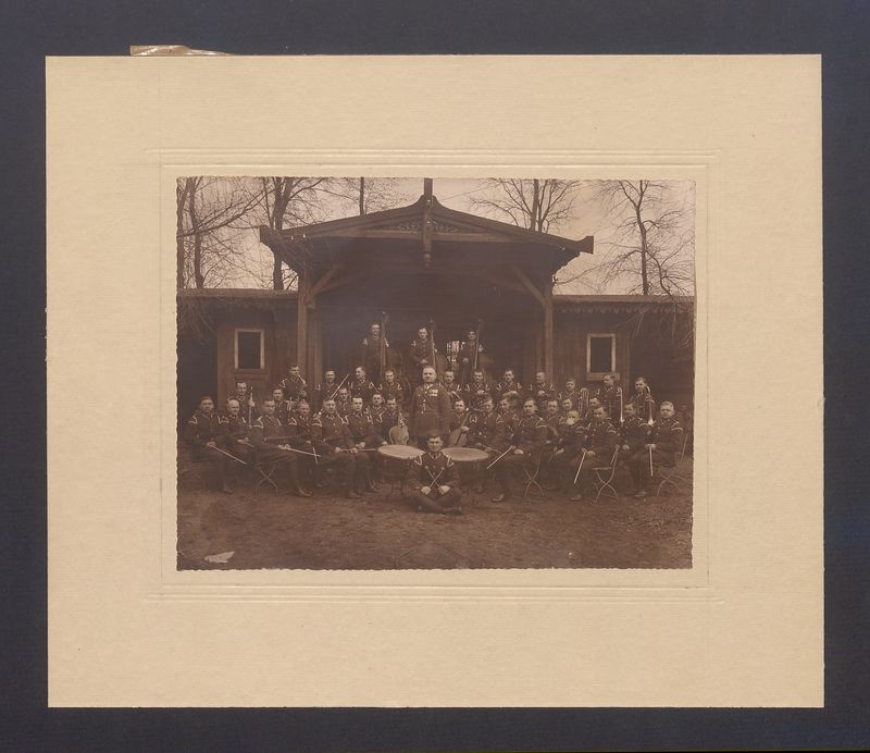 Orkiestra wojskowa 69 Pułku Piechoty na tle altany.