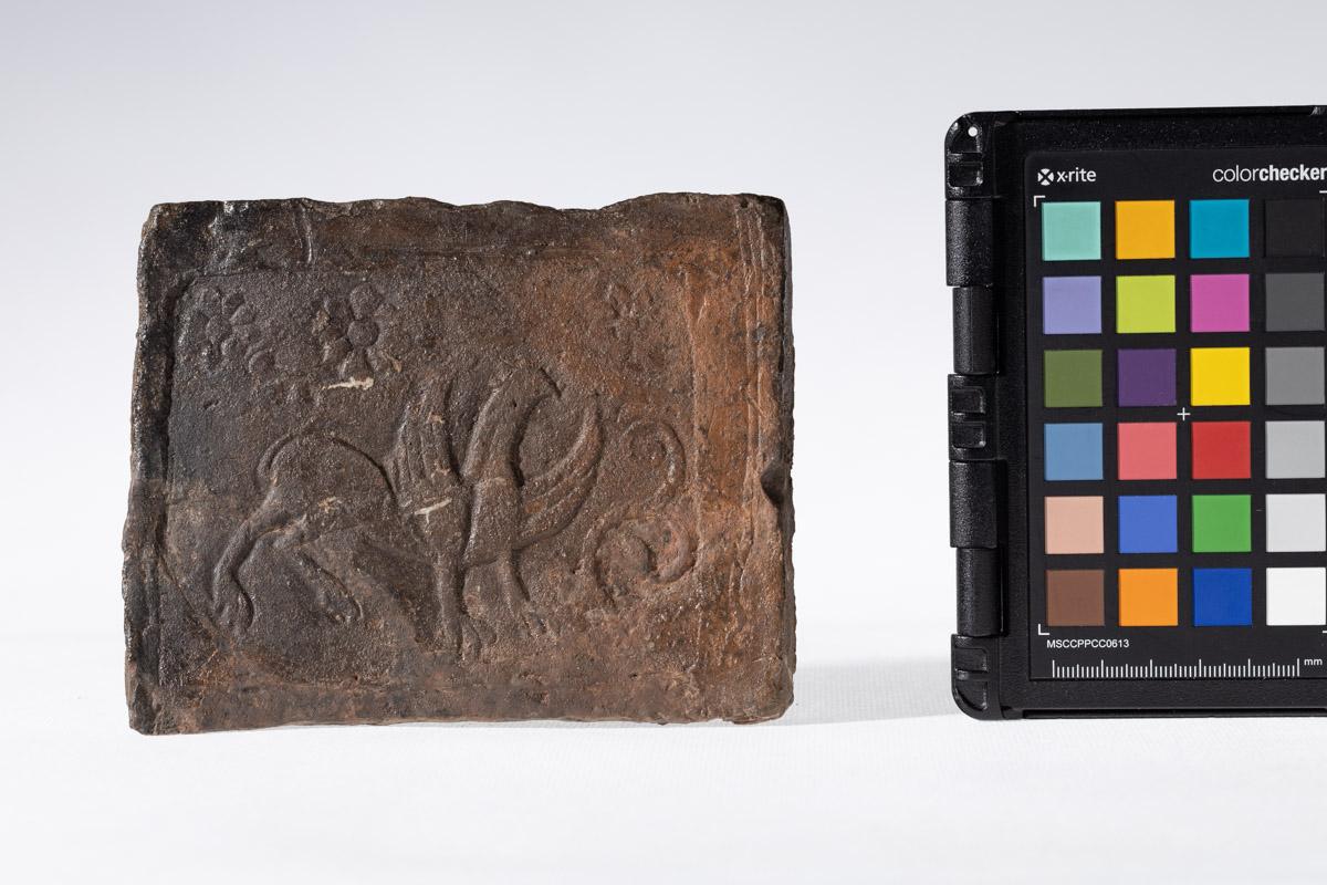 Płytka z motywem gryfa i rozetkami w tle