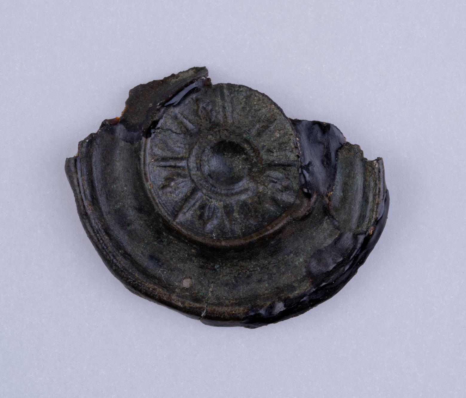 Fragment zdobionej tarczki z brązu