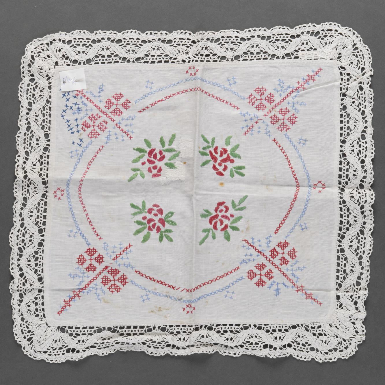 Serwetka biała z kolorowym haftem, obszyta koronką