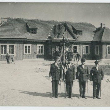 Poczet sztandarowy Kaliskiego Bractwa Kurkowego przed budynkiem strzelnicy