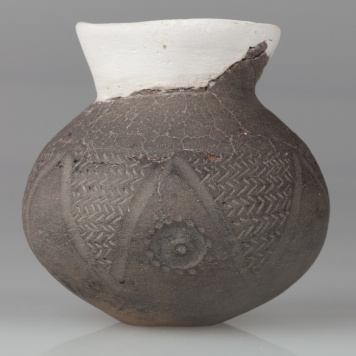 Czarka esowata o baniastym brzuścu, dnie wklęsłym, szyjce wychylonej na zewnątrz. Zdobiona ornamentem stempelkowym jodełkowym