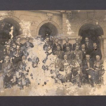 Grupa mężczyzn na dziedzińcu budynku.