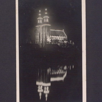 Widok na odświętnie iluminowaną bazylikę. Odbicie katedry w lustrze jeziora Jelonek.