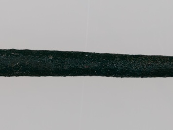 Fragmenty ozdób wykonanych z brązu, przepalonych na stosie, w tym skręt i szpila