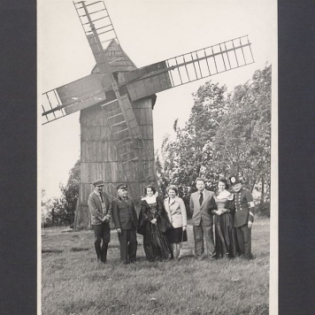 Siedmioosobowa grupa na tle wiatraka na Lednicy.