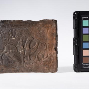 Płytka z motywem gryfa i rozetkami w tle